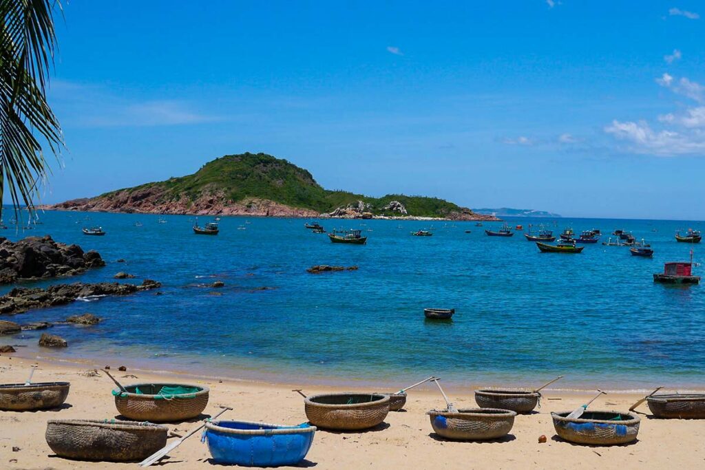 Korbboote am Strand von Bai Xep mit einer Insel in der Ferne - in der Nähe von Quy Nhon