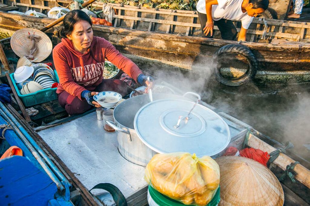 Pho vom Boot aus auf dem schwimmenden Markt von Cai Rang servieren