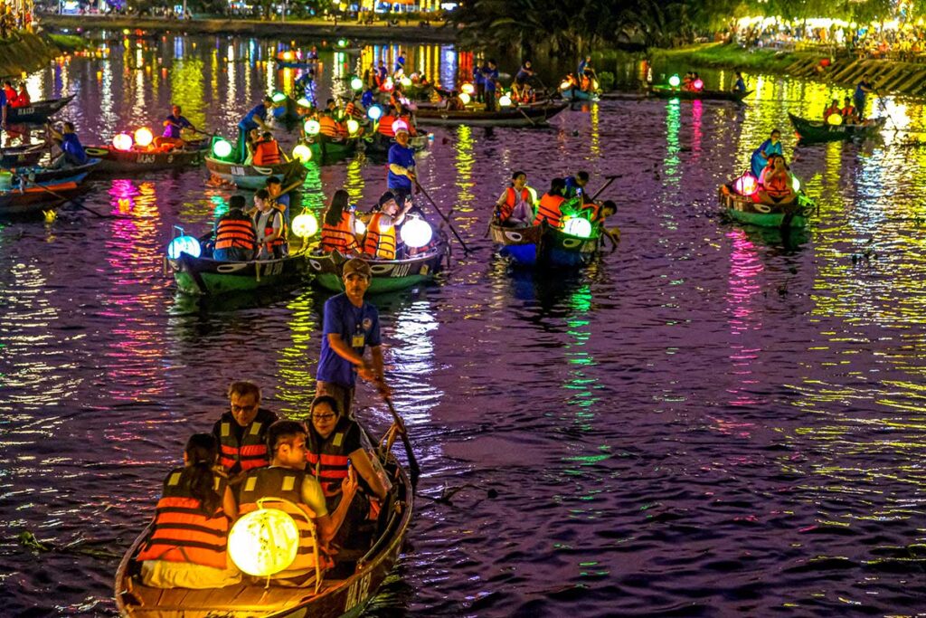 Hoi An bei Nacht – Boote mit Laternen fahren den Tho Bon-Fluss hinunter, der durch die Altstadt fließt