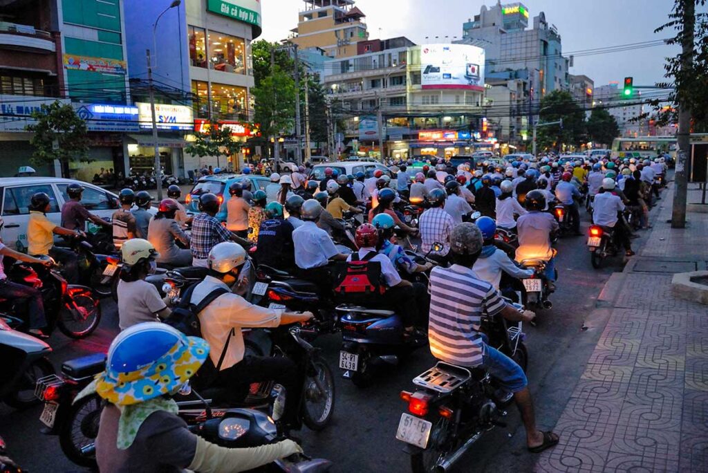 Motorräder in Vietnam fahren durch chaotischen Verkehr
