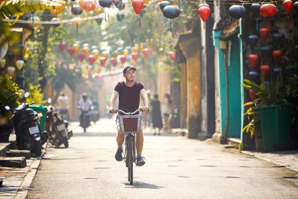 Tourist radelt durch die Straßen der Altstadt von Hoi An