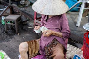 Vietnamesische Frau zählt vietnamesisches geld (Vietnam Dong)
