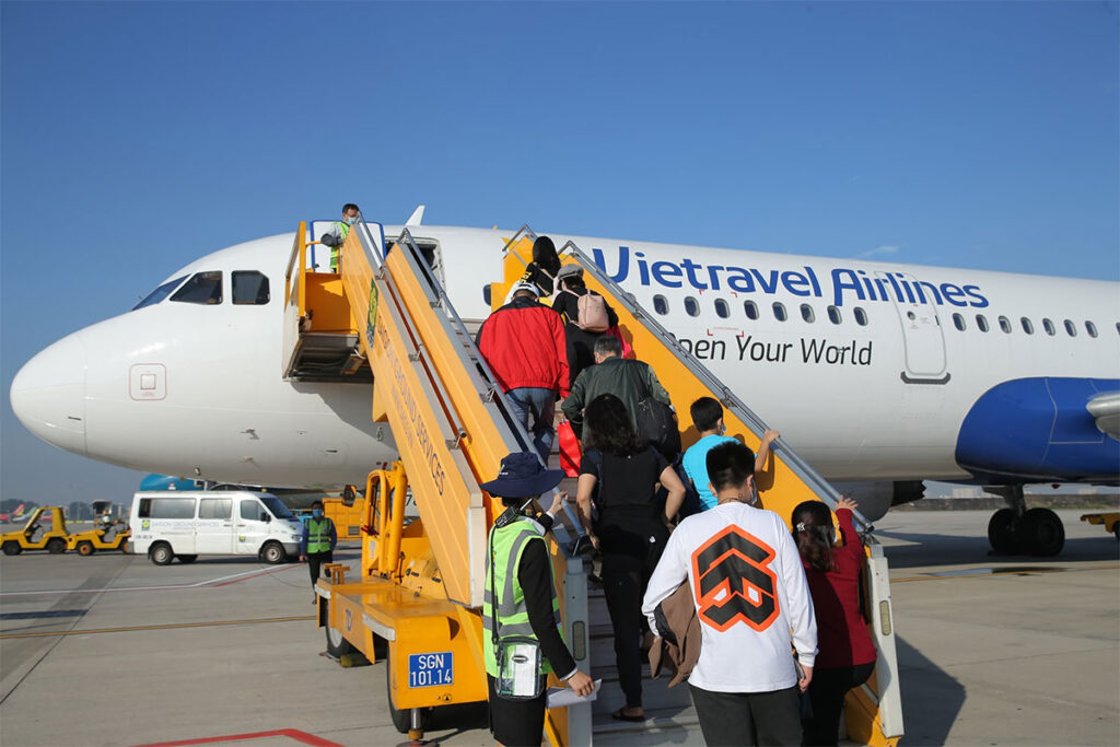 Menschen steigen in das Flugzeug der Vietravel Airlines in Vietnam