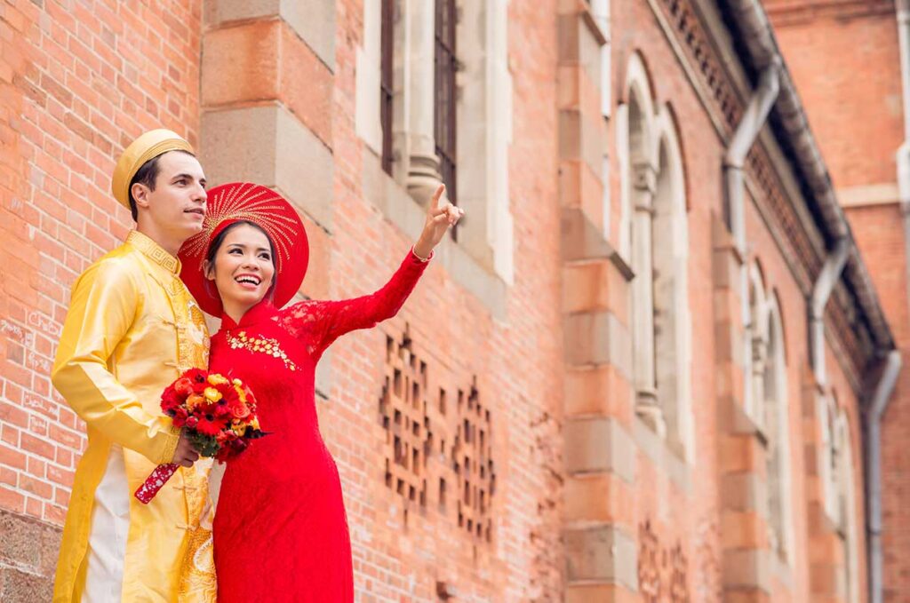 ein ausländischer Mann und eine vietnamesische Frau, die einen Ao Dai tragen