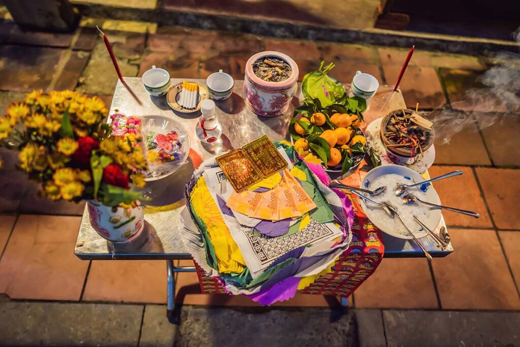 Ein Tisch vor einem Haus in Vietnam mit Essen zum Gebet für verstorbene Verwandte um Glück während des vietnamesischen Tet-Neujahrs