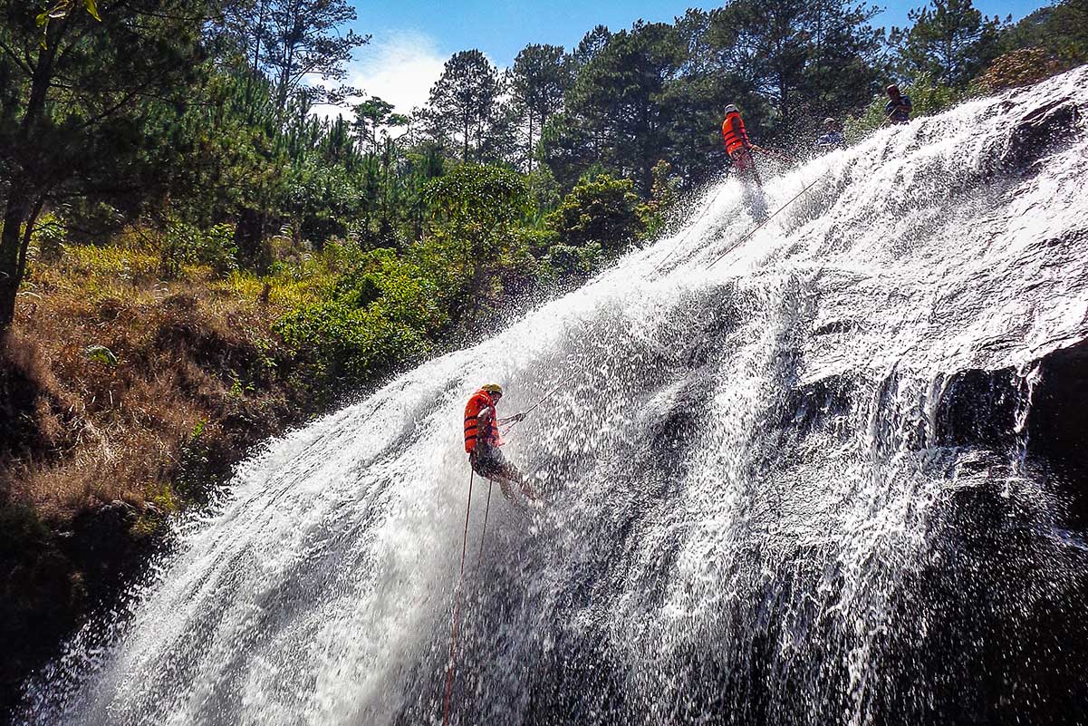 Canyoning in Dalat mit Abseilen von einem Wasserfall.