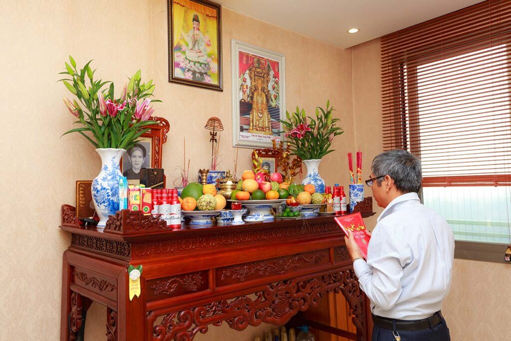 Mann betet an einem Altar zu Hause in Vietnam