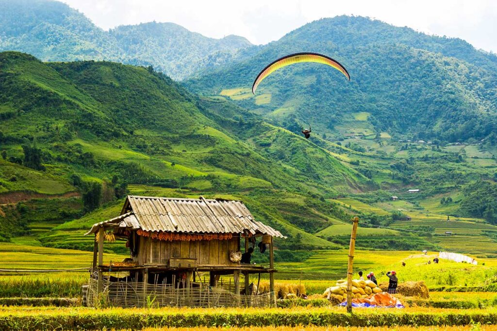 Gleitschirmfliegen über den terrassierten Reisfeldern von Mu Cang Chai in Vietnam
