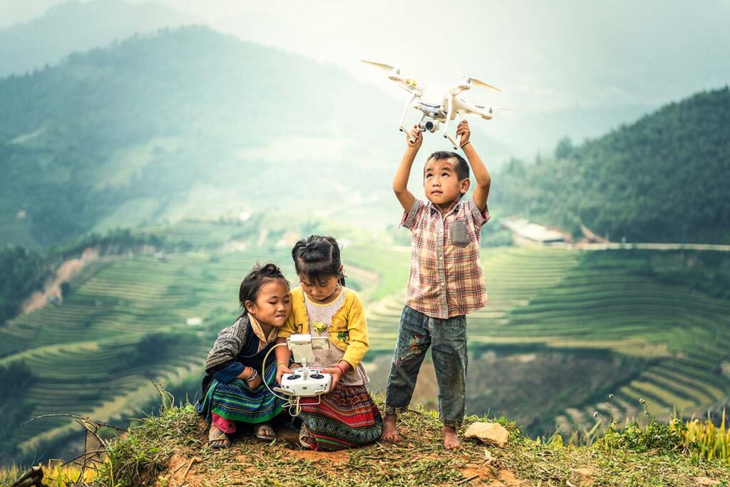 Fliegen mit Drohne in Vietnam mit ethnischen Kindern und Reisfeldern in Mu Cang Chai