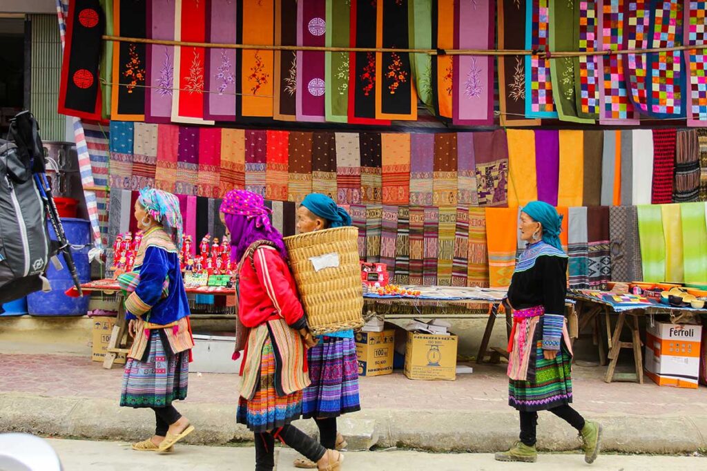 Ethnische traditionelle Kleidung, die an einem Stand auf dem Bac Ha-Markt hängt