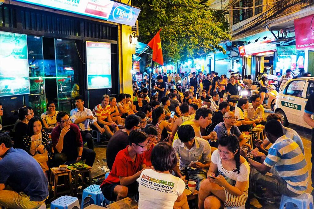 Einheimische und Touristen trinken Bier an der Kreuzung Bia Hoi in der Altstadt von Hanoi