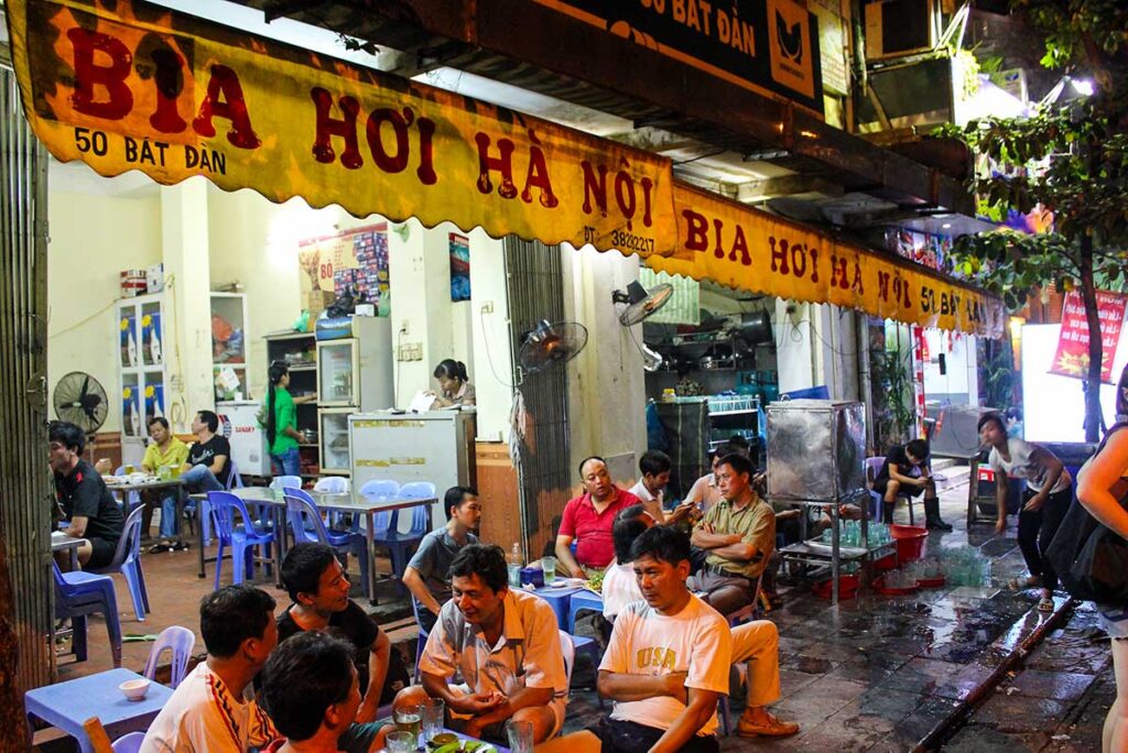 Menschen trinken Bia Hoi-Bier auf der Straße von Hanoi