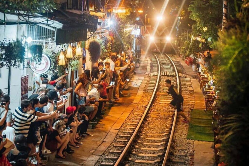 Hanoi Train Street mit Zug, der durch die Nachbarschaft fährt