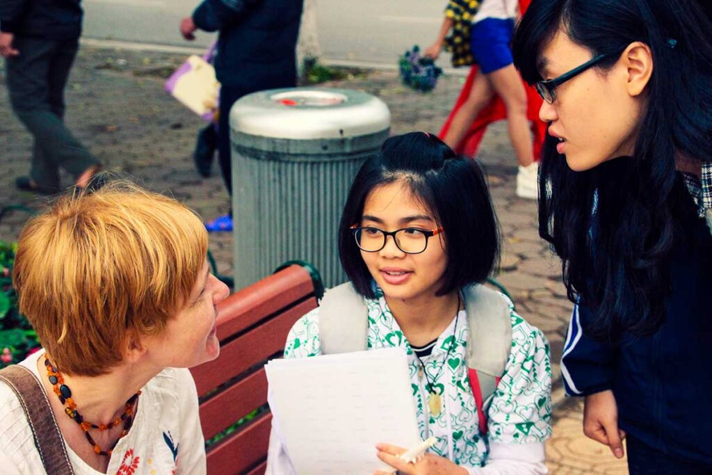 Studenten wenden sich am Hoan-Kiem-See an ausländische Touristen, um Englisch zu üben
