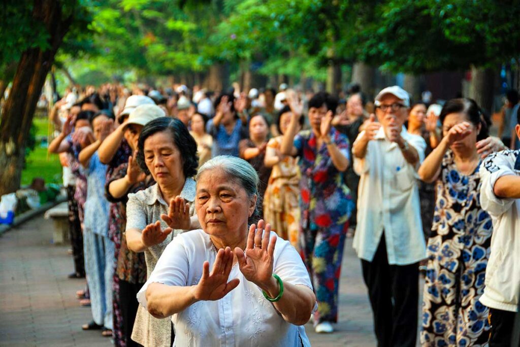 Ältere Einheimische aus Hanoi machen am frühen Morgen Tai Chi rund um den Hoan-Kiem-See