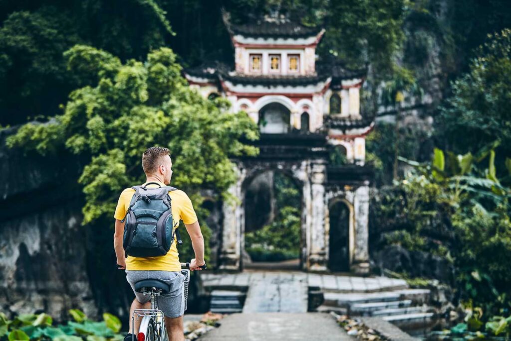 A tourist on a cycle infront of the Bich Dong Pagoda in Ninh Binh