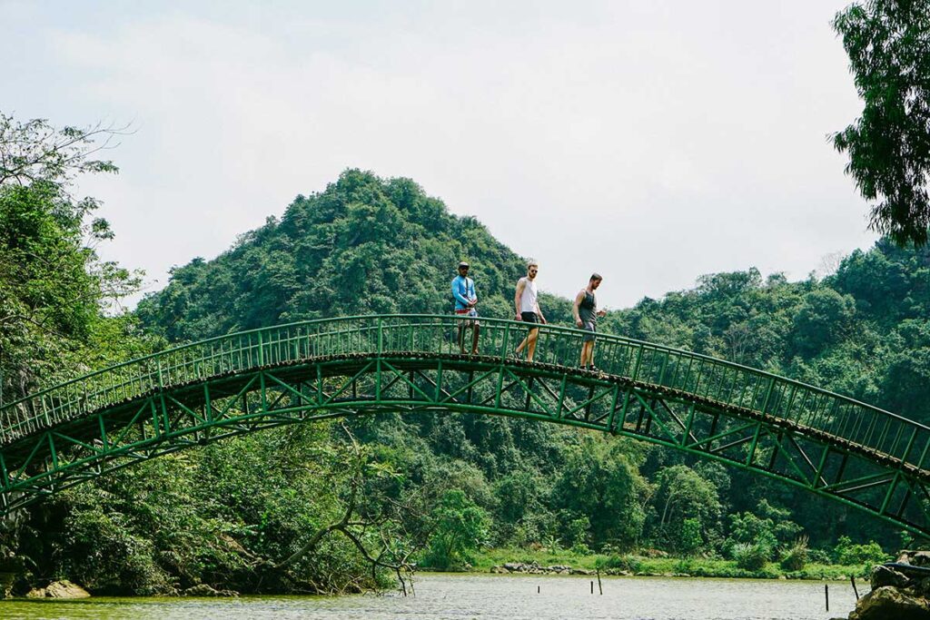 Touristen gehen über eine Brücke und erkunden den Vogelpark Thung Nam