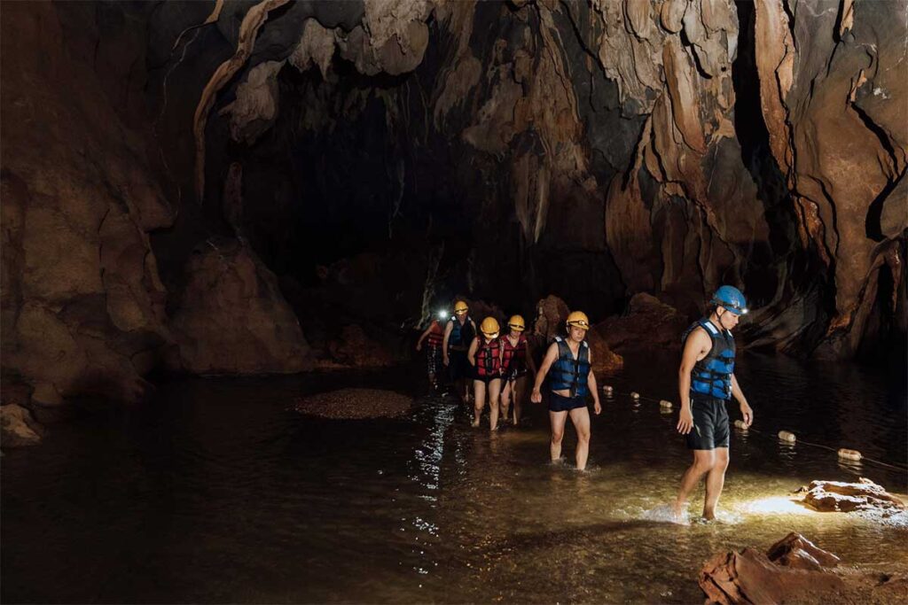 Eine Gruppe von Menschen kommt aus dem unterirdischen Fluss in der Dark Cave in Phong Nha