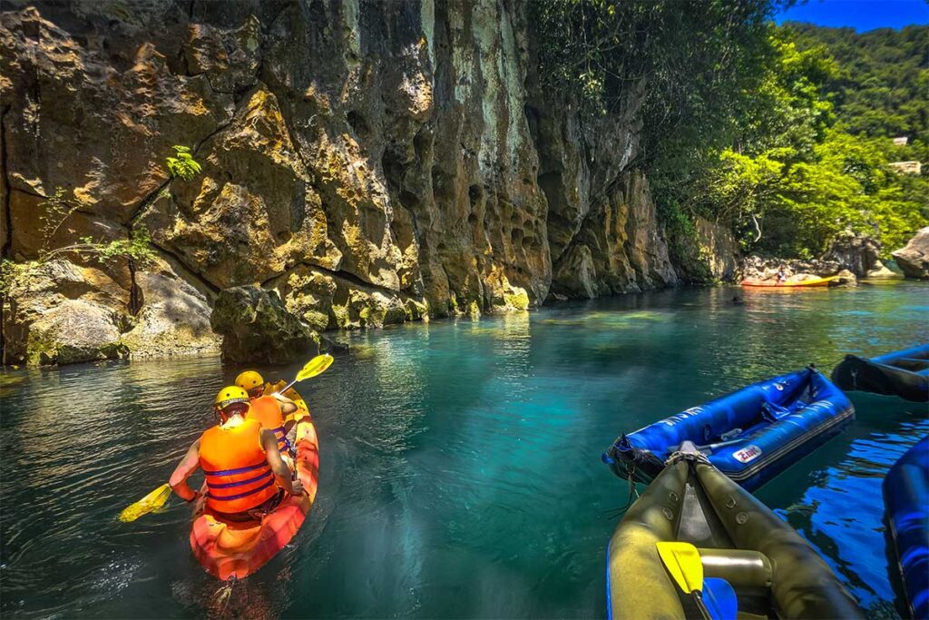 Menschen beim Kajakfahren auf dem Fluss bei Dark Cave