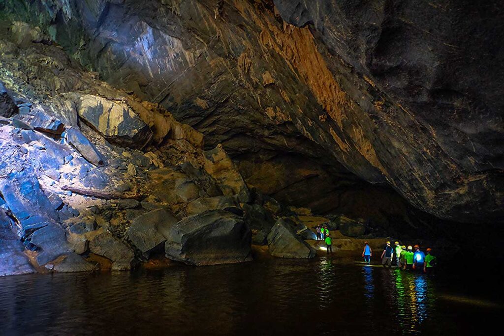 Eine Gruppe abenteuerlustiger Reisender unternimmt eine Höhlenexpedition in der Hang En-Höhle. Sie wandern durch einen unterirdischen See.