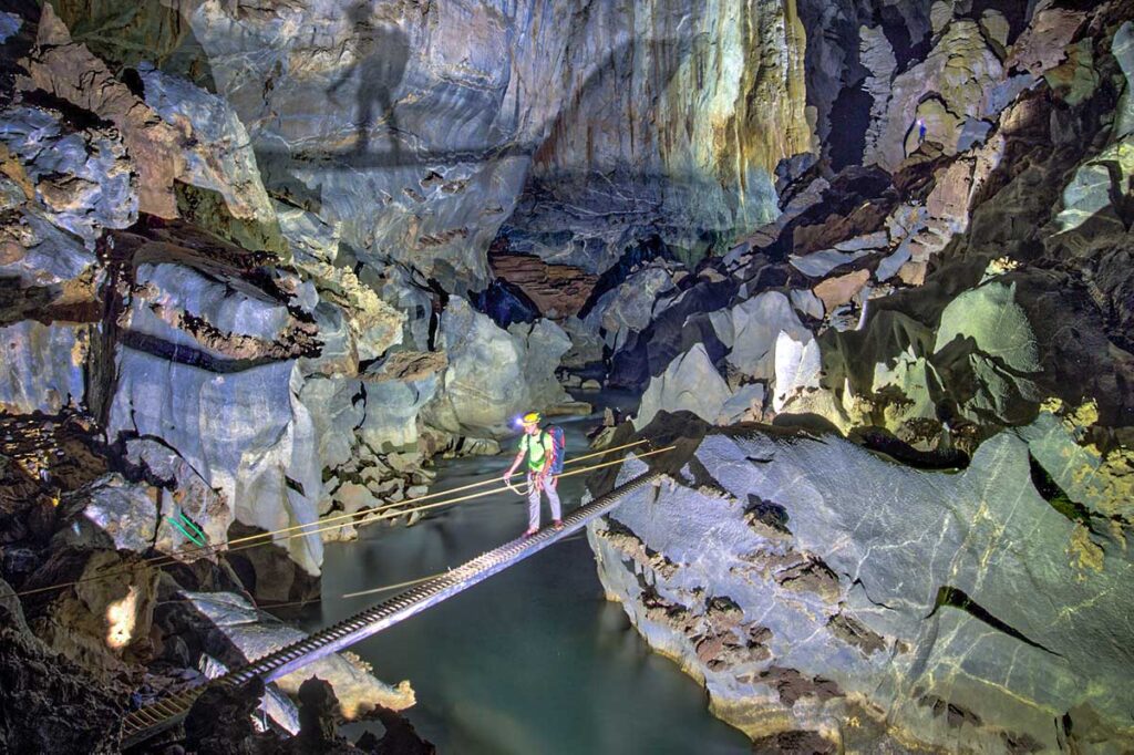 Ein Mann überquert einen unterirdischen Fluss über eine Brücke in der Hang Son Doong-Höhle in Vietnam