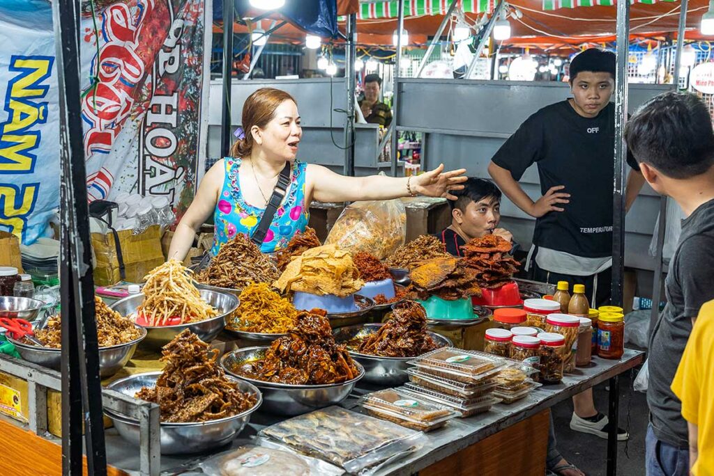 Frau verkauft Streetfood auf dem Son Tra Nachtmarkt in Da Nang