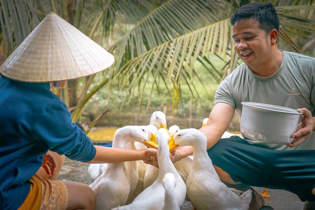 Touristen spielen mit Enten am Duck Stop in Phong Nha