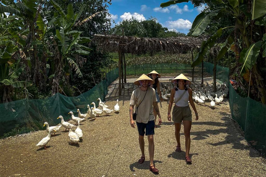 Touristen spielen mit Enten am Duck Stop in Phong Nha