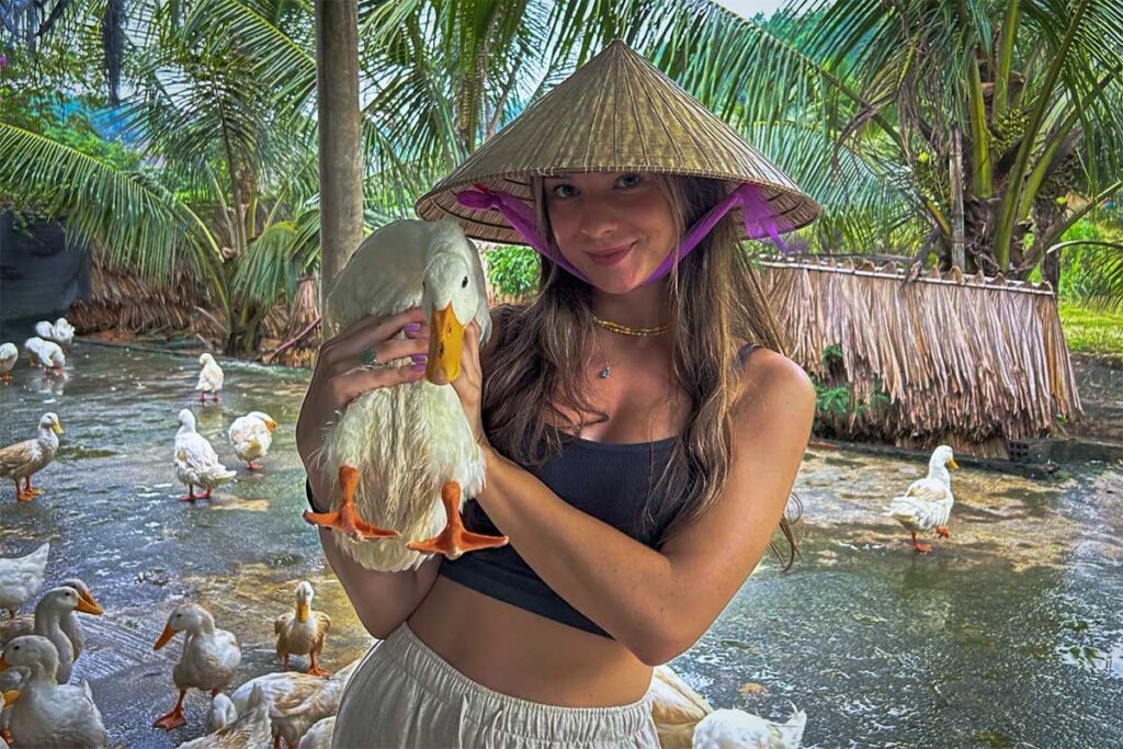 Touristen spielen mit Enten am Duck Stop in Phong Nha