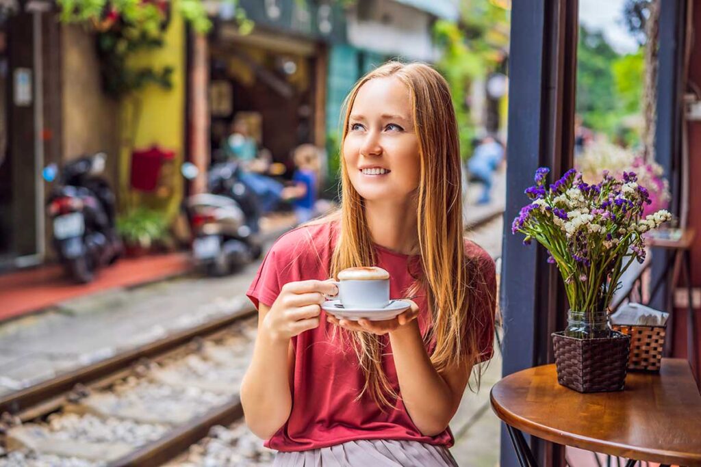 Ein Tourist trinkt einen vietnamesischen Eierkaffee in einem Café in der Hanoi Train Street