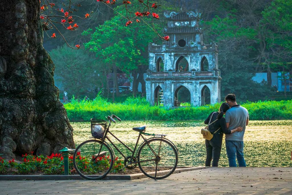 Ein romantisches Paar umarmt sich während der Flitterwochen in Vietnam vor dem Hoan-Kiem-See in Hanoi