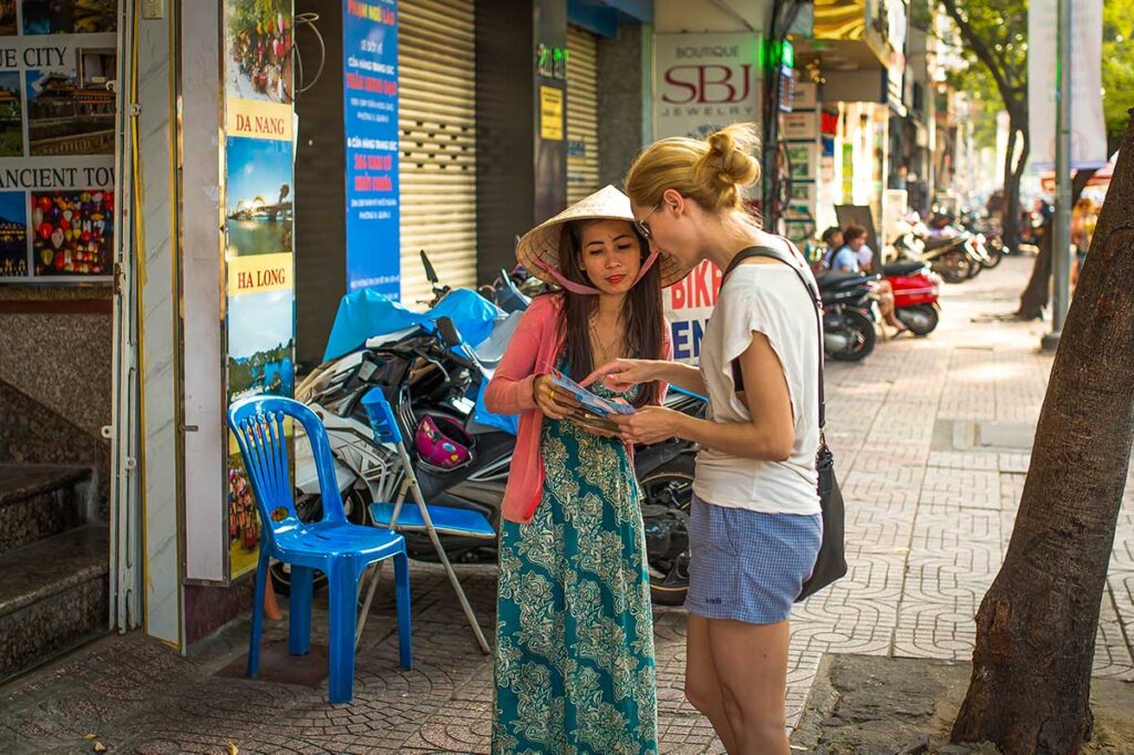 Eine allein reisende Frau bekommt auf der Straße in Vietnam von einem Einheimischen Reisetipps über Vietnam