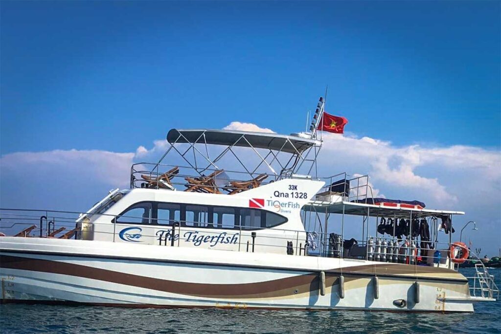 Tauchboot The Tigerfish von TigerFish Divers auf dem Wasser bei Hoi An mit Tauchflaschen und Neoprenanzügen an Bord — eines der Tauchboote, das Tagesausflüge zu den Cham-Inseln unternimmt