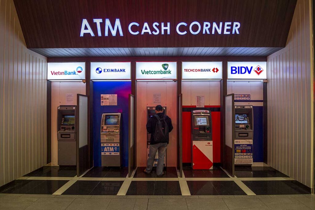 Reihe von Geldautomaten vietnamesischer Banken darunter Vietcombank, Techcombank und BIDV in einem ATM Cash Corner, wo Reisende mit Wise oder einer anderen ausländischen Karte vietnamesische Dong abheben können