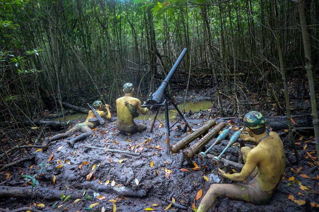 Wachsfiguren von Vietcong-Guerillakämpfern im Schlamm des Sac-Waldes im Can Gio Reservat, mit einer Mörserstellung und Munition zwischen den Mangroven — eine der Rekonstruktionen, die die Lebensbedingungen der Guerilla während des Vietnamkriegs zeigen