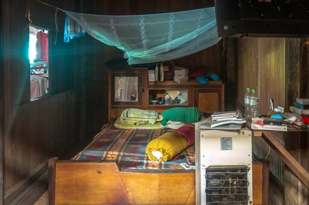 Schlafzimmer in einem einfachen Haus in Vietnam mit einem Moskitonetz über dem Bett als Schutz vor Mücken