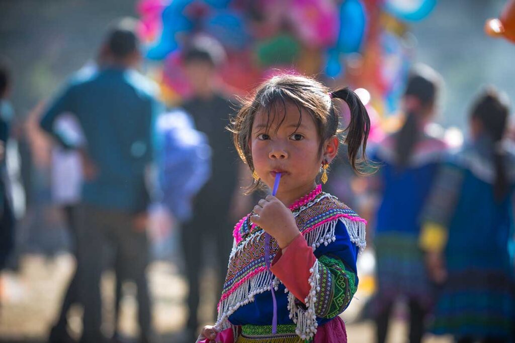 Junges Mädchen in traditioneller Hmong-Tracht in Nordvietnam, ein Beispiel warum verantwortungsvolle Reisende in Vietnam Kindern auf der Straße keine Süßigkeiten oder Geld geben