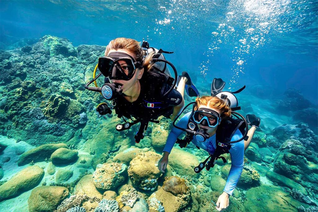 Zwei Scubataucher schwimmen Seite an Seite über ein Korallenriff bei den Cham-Inseln — Tauchen bei Hoi An eignet sich dank der vielfältigen Tauchplätze sowohl für Anfänger als auch für erfahrene Taucher