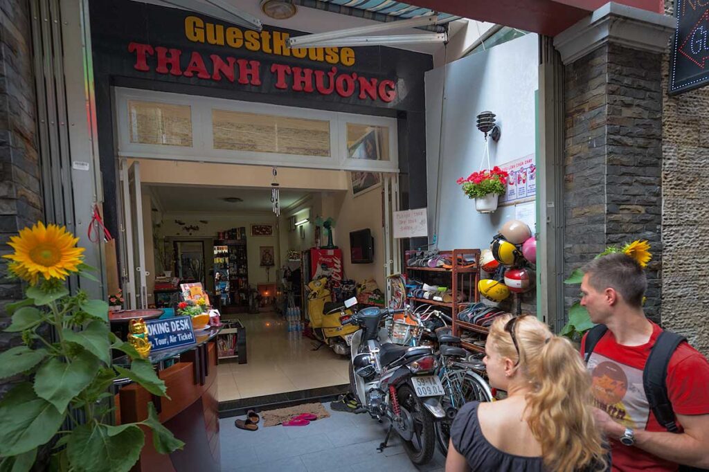 Westliche Reisende am Eingang eines lokalen vietnamesischen Guesthouses, in lokalen Unterkünften zu übernachten ist eine Möglichkeit verantwortungsvoll zu reisen und die lokale Wirtschaft in Vietnam zu unterstützen