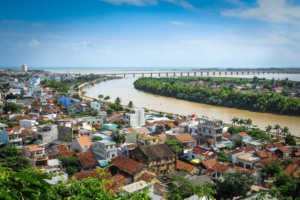Blick über die Stadt Tuy Hoa in Phu Yen mit bunten Häusern, einem breiten Fluss mit einer langen Brücke und dem Meer in der Ferne — die Hauptstadt von Phu Yen ist eine ruhige Küstenstadt an der nationalen Route