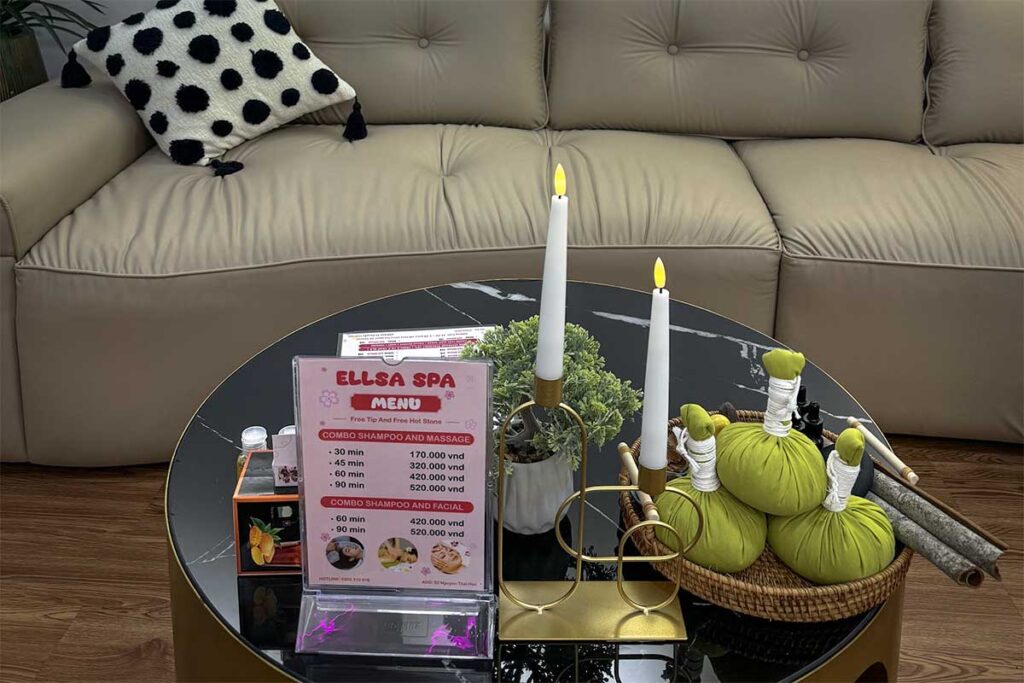 Massagemenü des Ellsa Spa in Vietnam auf einem Couchtisch mit Preisen in vietnamesischem Dong für Shampoo- und Massagekombinationen