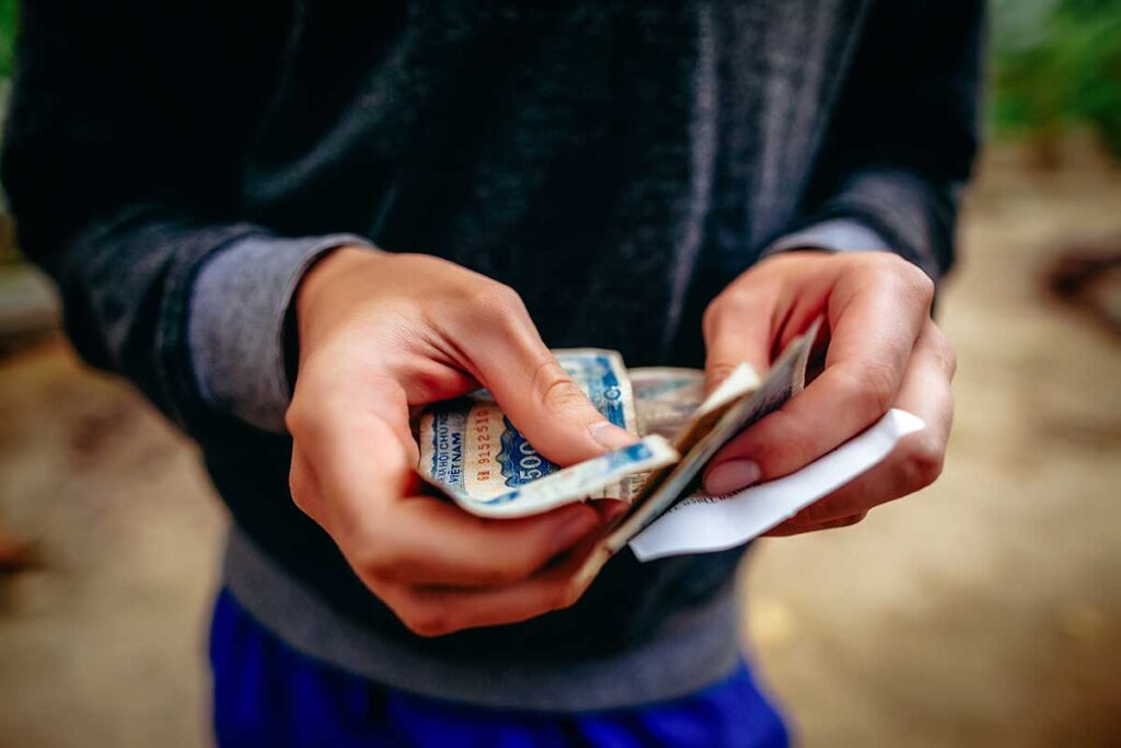 Hände zählen vietnamesische Dong-Scheine, Barzahlung bleibt in Vietnam die am häufigsten verwendete Zahlungsmethode auch für Wise-Nutzer die Geld abgehoben haben
