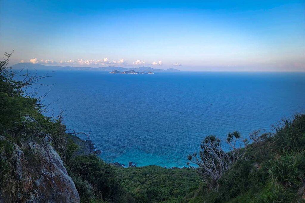Weiter Meeresblick vom Aussichtspunkt der Hon Heo Halbinsel in der Van Phong Bay, mit Inseln am Horizont und üppiger Küstenvegetation im Vordergrund